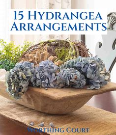 a wooden bowl filled with blue flowers on top of a table