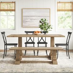 a dining room table with four chairs and a bench