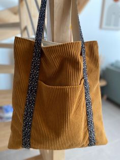 a brown bag hanging from a wooden post in front of a stair case with blue and white trim