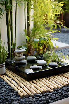 there is a tray with rocks and bamboo in the middle on top of some stones