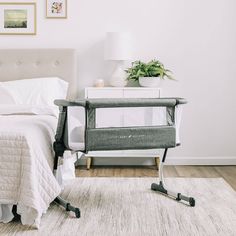 a baby crib sitting next to a bed in a bedroom