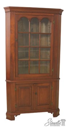 a wooden china cabinet with glass doors on the top and bottom shelves, in an antique style