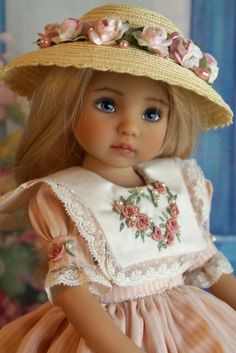 a doll wearing a dress and hat with flowers on it's brimmed head