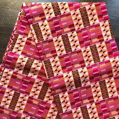 an orange and red patterned cloth sitting on top of a wooden table