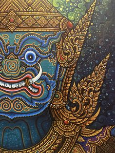 an intricately painted painting of a face with blue eyes and gold details on it