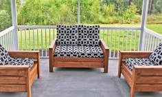 two wooden chairs sitting on top of a porch