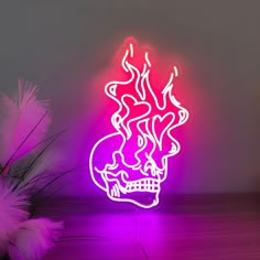 a neon sign with a skull and flames on it in the middle of a room