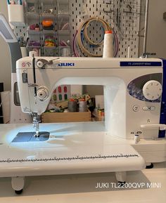 a white sewing machine sitting on top of a table