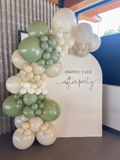 the balloon arch is decorated with white and green balloons