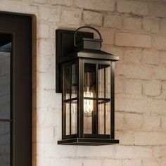 an outdoor light hanging from the side of a brick wall