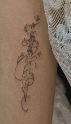 a woman's leg with a tattoo on it and a knife in the middle