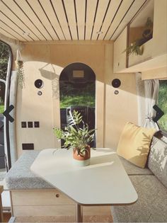 the inside of a camper with a table and bench in front of it,