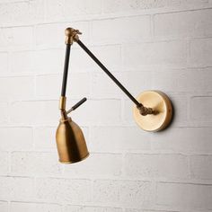 a wall light that is on the side of a brick wall with two lights attached to it