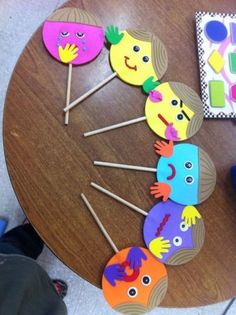 a wooden table topped with lots of colorful cupcakes on top of stickers