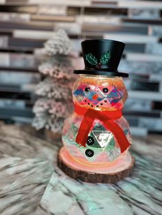 a glass snowman with a top hat and red scarf