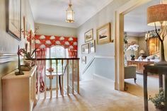 an entry way with red curtains and pictures on the wall