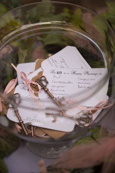 there are many different items in the glass bowl on the table, including scissors and cards