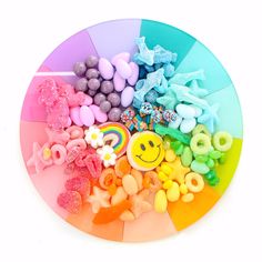 there are many candies arranged in the shape of a rainbow on top of a plate