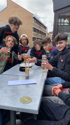 a group of people sitting around a table drinking beer