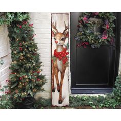 the door is decorated with christmas wreaths and deer's head painted on it