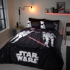 a star wars themed bed in a white room with black comforter and pillow cases