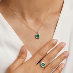 Dainty and feminine, our Emerald Princess Ring from the Envy collection is an instant icon. A dazzling emerald fusion stone ring serves as the focal point from a delicate masterfully crafted from hypoallergenic 925 sterling silver and plated in 14K gold. This timeless design is completed with the addition of round-cut cubic zirconia enveloping the emerald to make the vibrant green pop all the more. Metal: 925 Silver Plating: 14K Gold E-coated Size: 6-9 Adjustable Stone: Emerald Fusion Stone with Luxury Fine Jewelry Emerald Necklace, Emerald Sets Jewellery, Emerald Pendant Design, Elegant Emerald Cubic Zirconia Ring With Halo, Elegant Emerald Ring With Halo In Cubic Zirconia, Elegant Emerald Halo Ring With Cubic Zirconia, Classic Rose Gold Emerald Jewelry, Green Emerald Jewelry With Halo Detail, Green Emerald Halo Jewelry