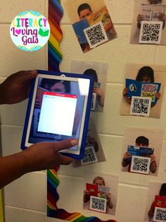 a person holding an electronic device in front of a wall with qr code on it