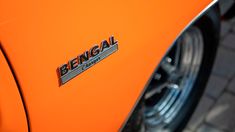 an orange car with the word bengal on it's emblem is seen in this close up photo