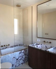 a bathroom with marble counter tops and two sinks