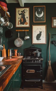 a kitchen with green walls and pictures hanging on the wall, including an old fashioned stove