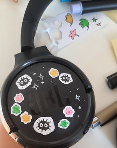 a black headphone sitting on top of a table next to markers and pencils