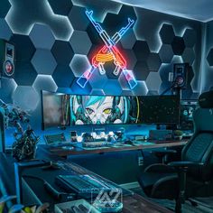 a computer desk topped with a monitor and keyboard in front of a neon wallpaper