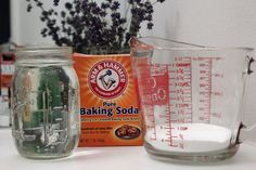 ingredients for baking in glass measuring cups on counter next to jar and container with purple flowers