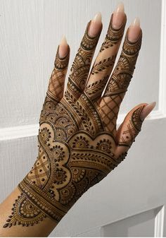 a woman's hand with henna tattoos on it