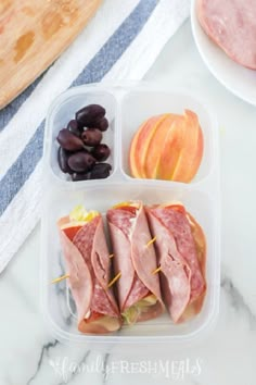 two plastic containers filled with food on top of a white marble counter next to an apple