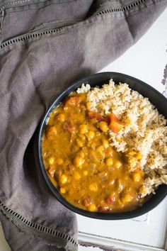 a bowl filled with rice, beans and carrots next to a napkin on top of a window sill