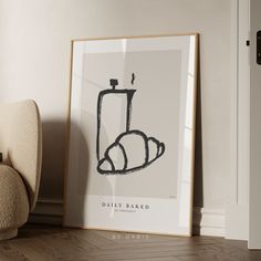 a framed poster with a drawing of a toilet in the corner next to a chair