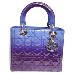 Introducing a work of art in the form of a handbag - the Christian Dior Patent Cannage Gradient Medium Lady Dior Bag. Crafted with exquisite attention to detail, this bag is a true masterpiece of luxury fashion, designed to make a vibrant and unforgettable statement. This Lady Dior bag is a symphony of color, transitioning from shades of purple to mesmerizing blues. The gradient effect adds depth and dimension, making it a striking and unique accessory. Crafted from polished box calf leather, this bag exudes luxury. The tactile and glossy surface of the leather not only looks stunning but also feels sumptuous to the touch. With reinforced leather top handles and an optional shoulder strap, you have versatile ways to carry this bag. It's designed for both fashion and function, ensuring it c Gucci Dress, Dior Addict, Purple Leather, Purple Bags, Lady Dior Bag, Lady Dior, Accessories Unique, Bag Straps, Leather Top