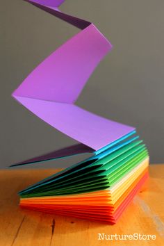 a stack of folded paper sitting on top of a wooden table