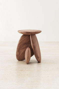 a wooden stool sitting on top of a white floor