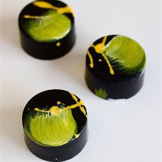 three black and yellow painted knobs on a white surface