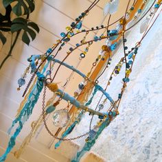 a close up of a wind chime hanging from a ceiling with beads and chains