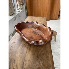 a wooden bowl sitting on top of a table