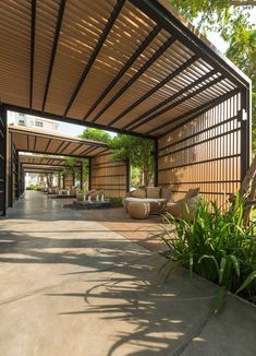 an outdoor covered area with benches and plants