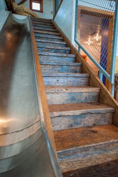 an escalator with wooden steps leading up to the second floor