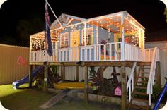 a house that is lit up with christmas lights on the front porch and second story deck