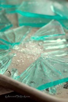 some broken glass pieces sitting on top of a table with blue ribbon around the edges