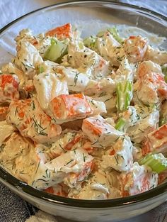 a glass bowl filled with crab salad on top of a table