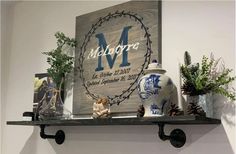 a couple of vases sitting on top of a shelf next to a sign with the letter m