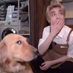 a man sitting next to a brown dog